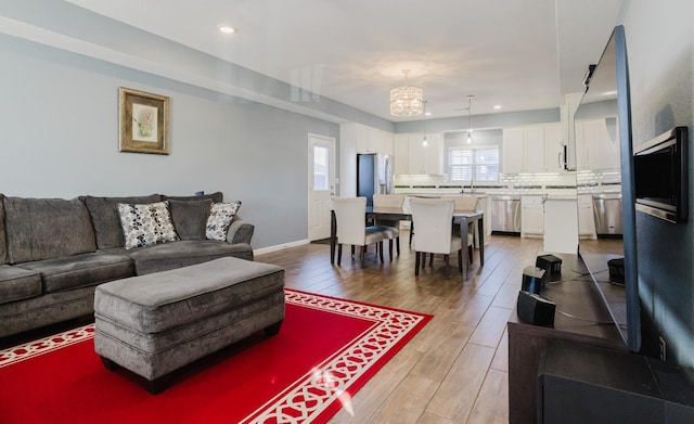 living room featuring sink and an inviting chandelier