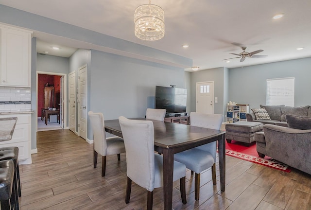 dining room with ceiling fan with notable chandelier