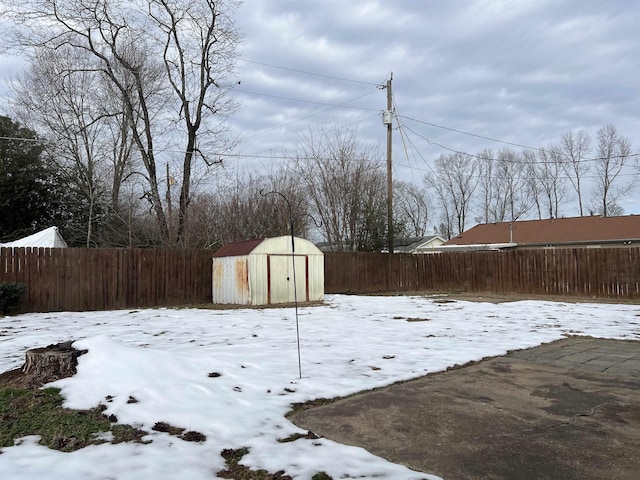 snowy yard with a storage shed