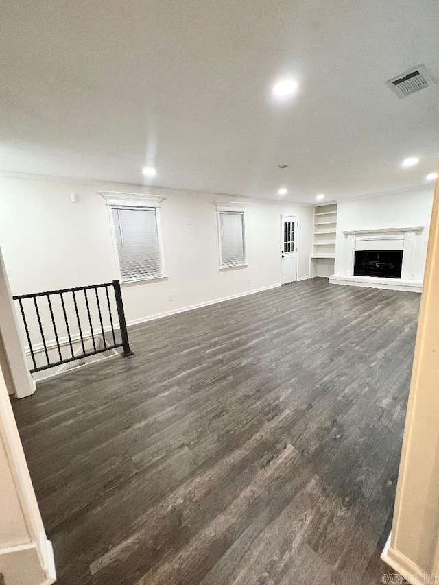 unfurnished living room with dark wood-type flooring and built in features