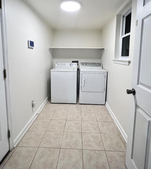 clothes washing area with light tile patterned floors and washer and clothes dryer