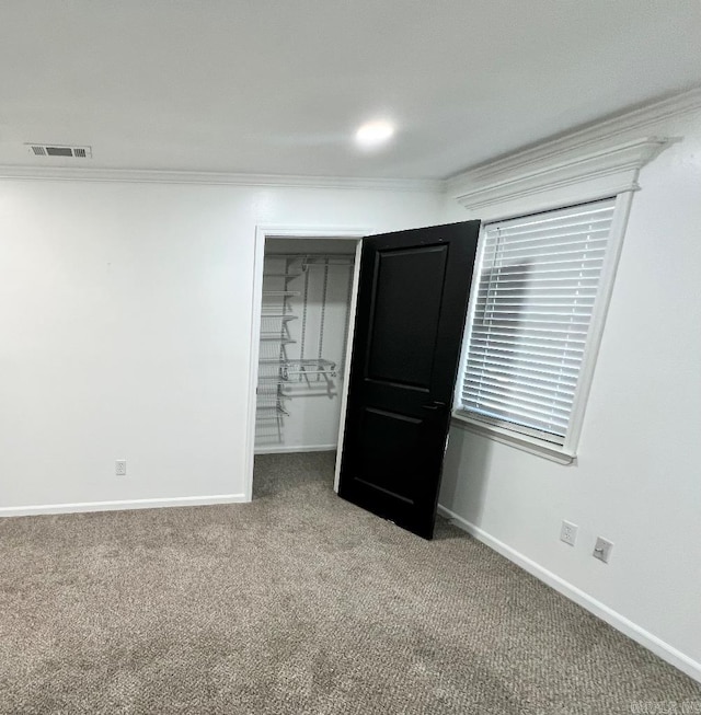 unfurnished bedroom featuring crown molding, carpet floors, and a closet