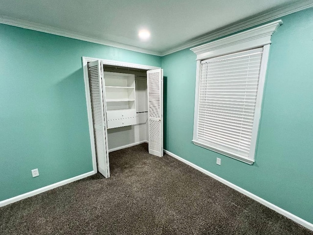 unfurnished bedroom featuring ornamental molding, a closet, and dark colored carpet