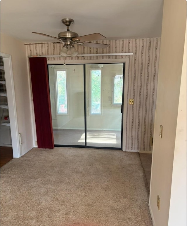 carpeted spare room with ceiling fan