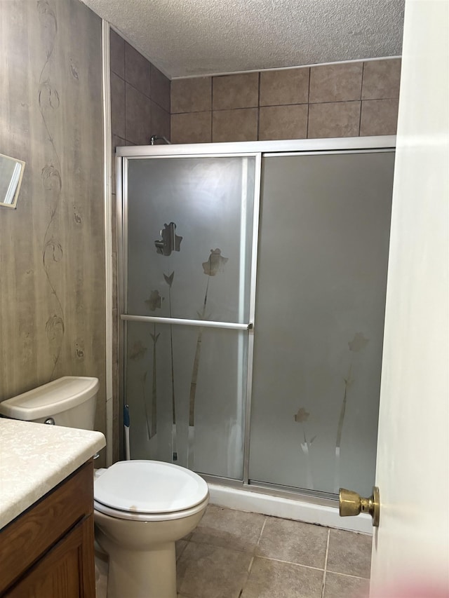 bathroom with vanity, toilet, a textured ceiling, and walk in shower