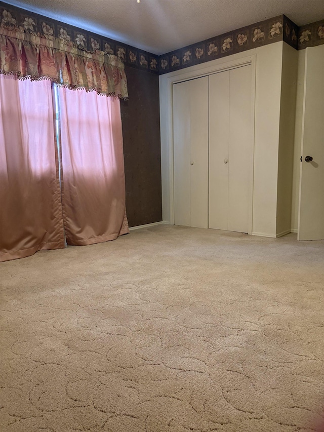 unfurnished bedroom with carpet flooring, a closet, and a textured ceiling