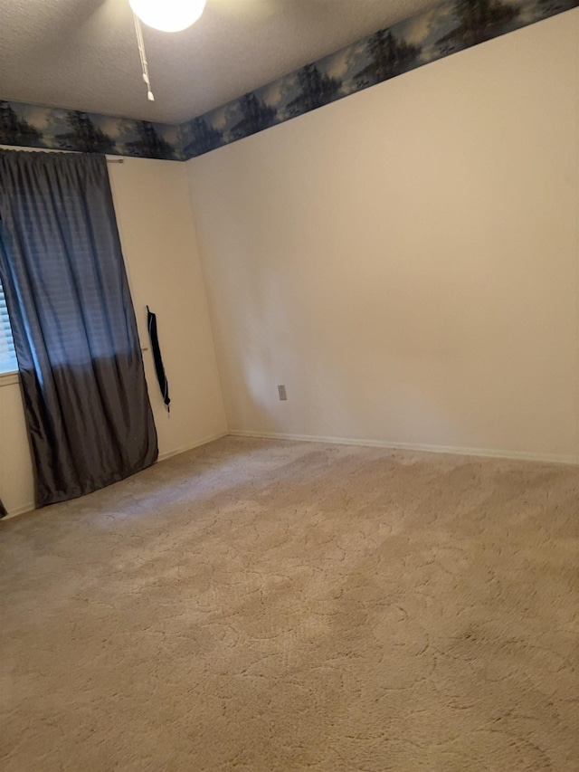 carpeted empty room with a textured ceiling