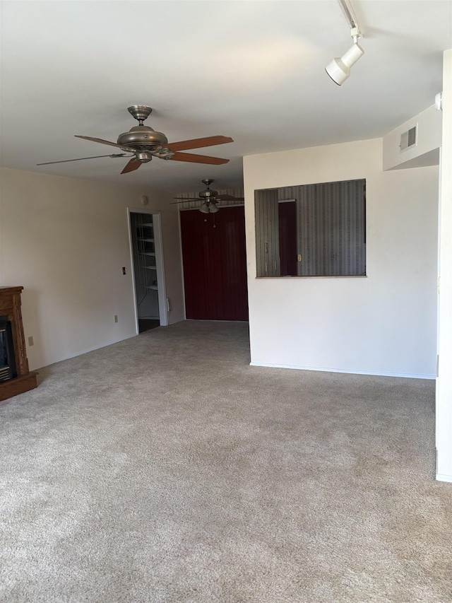 spare room with carpet floors, ceiling fan, and track lighting