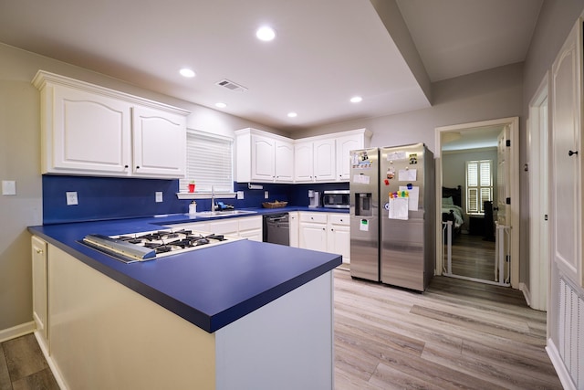 kitchen featuring sink, stainless steel appliances, light hardwood / wood-style floors, and white cabinets