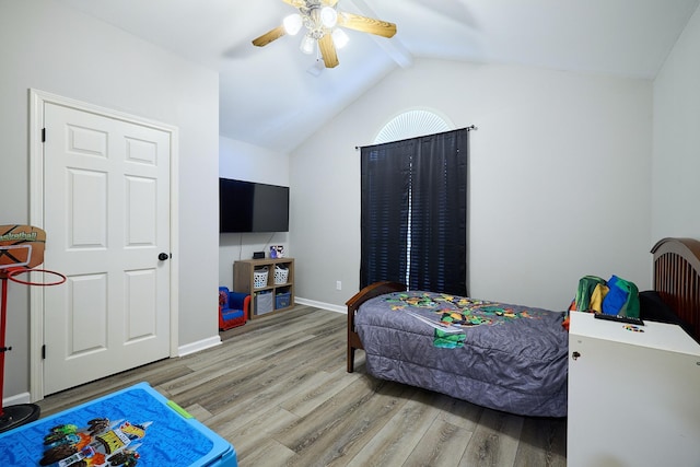 bedroom with hardwood / wood-style flooring, ceiling fan, and vaulted ceiling with beams