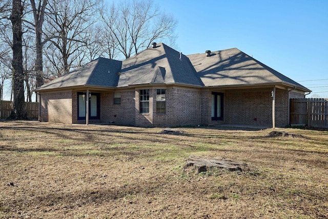 rear view of property with a lawn