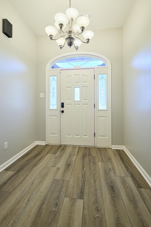 foyer entrance featuring hardwood / wood-style flooring and a chandelier