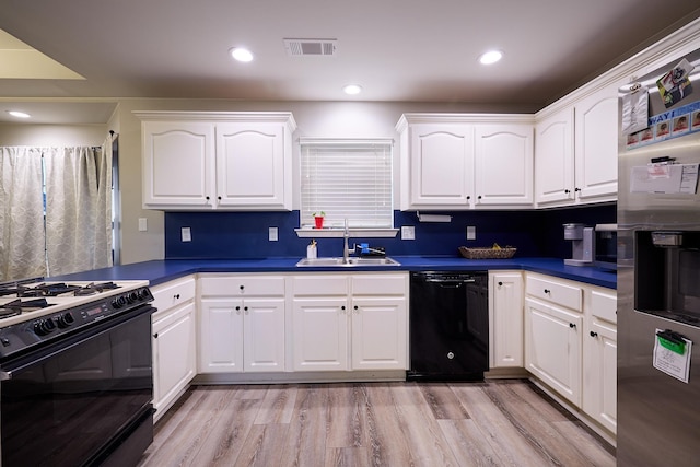 kitchen featuring sink, white cabinets, light hardwood / wood-style floors, and black appliances