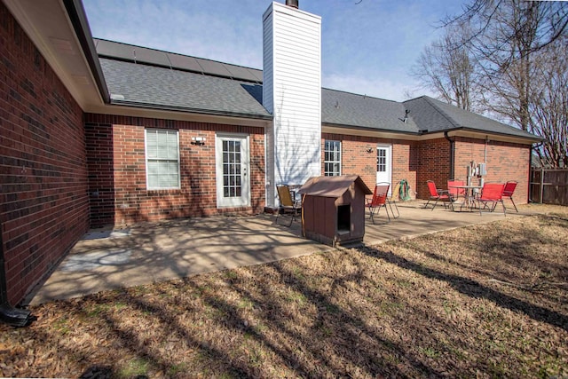 back of house with a yard and a patio