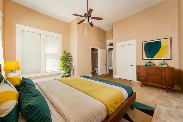 bedroom with ceiling fan, vaulted ceiling, and light wood-type flooring