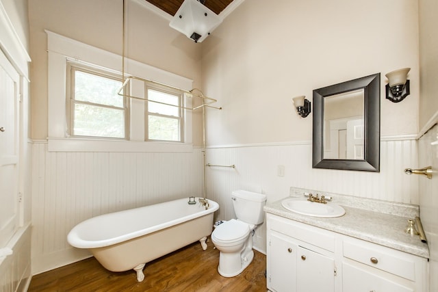 bathroom with wood-type flooring, toilet, vanity, and a washtub