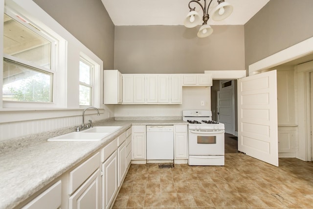 kitchen with white appliances, sink, a high ceiling, and white cabinets