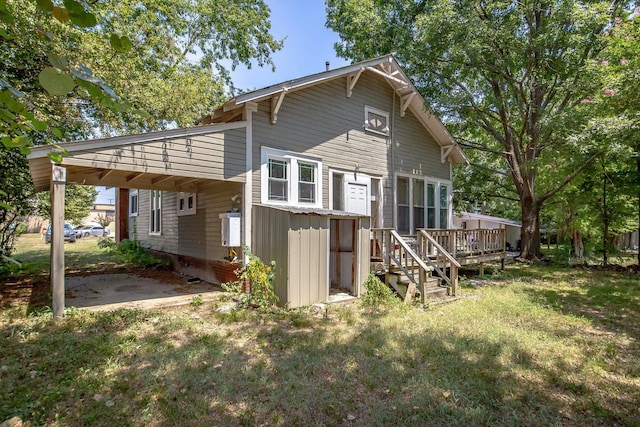 back of house featuring a wooden deck and a yard