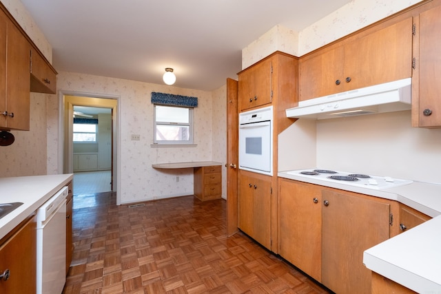 kitchen with white appliances and parquet flooring