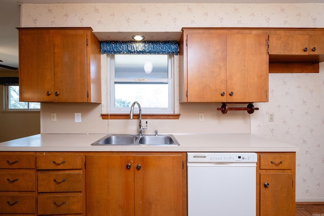 kitchen featuring dishwasher, sink, and parquet floors