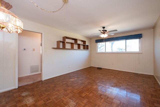 spare room with dark parquet flooring and ceiling fan with notable chandelier