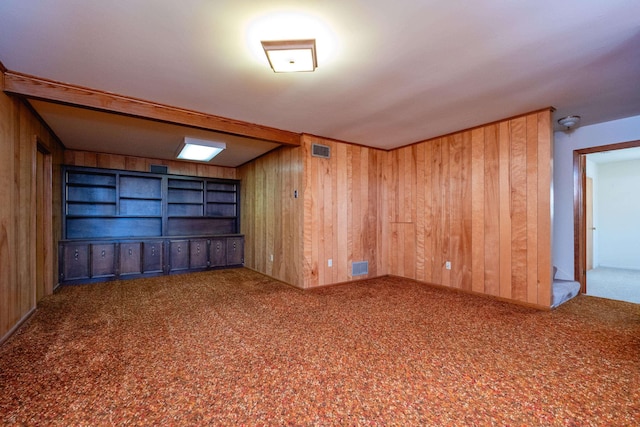 spare room featuring carpet floors and wooden walls