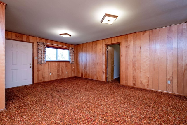 unfurnished room featuring wooden walls