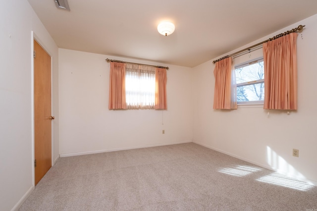 spare room featuring carpet floors and a wealth of natural light