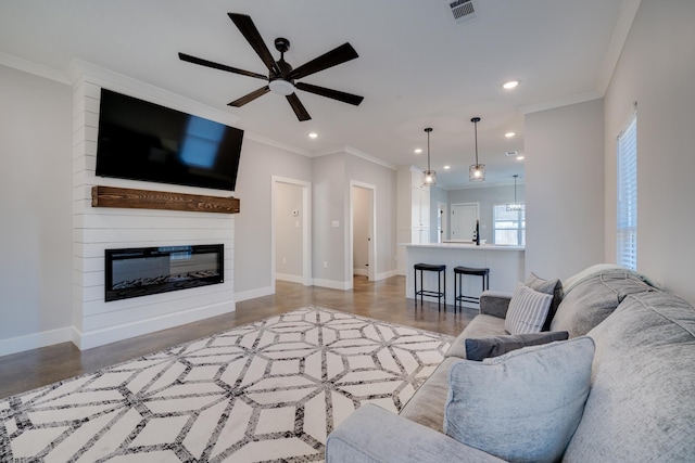 living room with a fireplace, ornamental molding, and ceiling fan