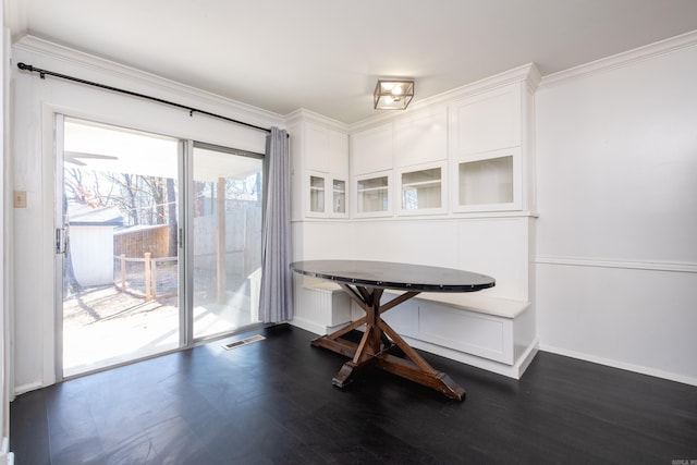 dining area featuring dark wood-style floors, breakfast area, visible vents, ornamental molding, and baseboards