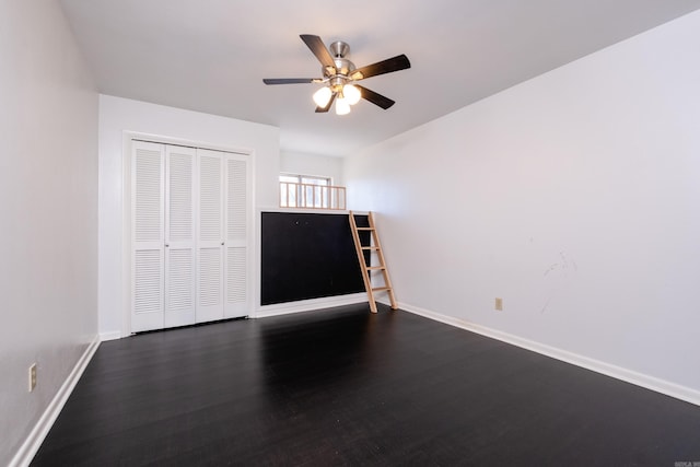 unfurnished bedroom featuring ceiling fan, dark wood-type flooring, a closet, and baseboards