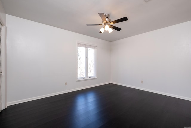 unfurnished room with ceiling fan, dark wood-type flooring, and baseboards