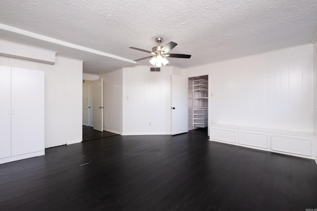 spare room with ceiling fan, a textured ceiling, visible vents, and dark wood-type flooring