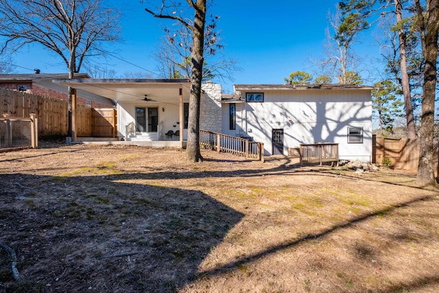 rear view of property featuring ceiling fan and a lawn