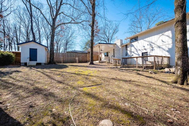 view of yard featuring an outdoor structure, fence, and a storage unit