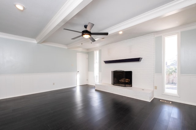 unfurnished living room with ceiling fan, dark hardwood / wood-style floors, a fireplace, ornamental molding, and beamed ceiling