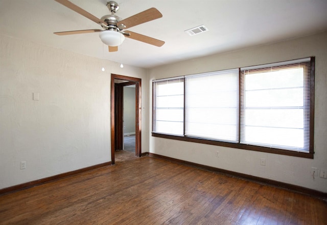 empty room with a healthy amount of sunlight and dark hardwood / wood-style flooring