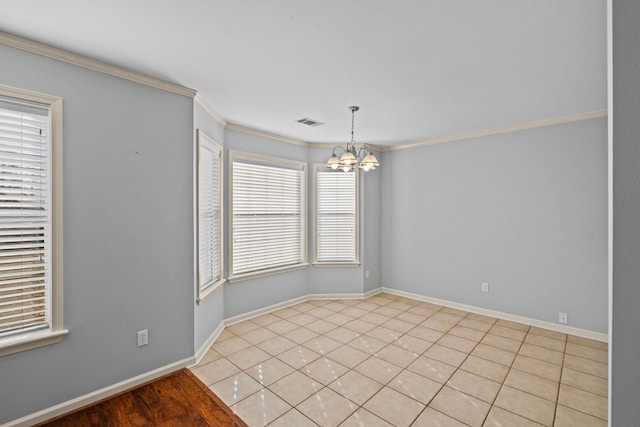 spare room with ornamental molding, light tile patterned floors, and a chandelier