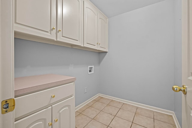 clothes washing area featuring cabinets, hookup for a washing machine, and light tile patterned floors