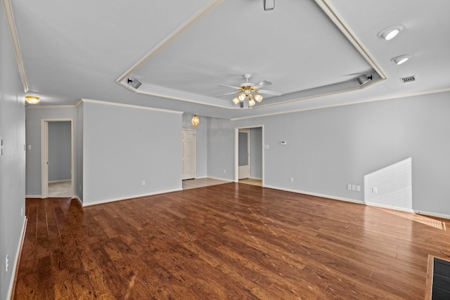 interior space featuring hardwood / wood-style flooring, ceiling fan, ornamental molding, and a tray ceiling