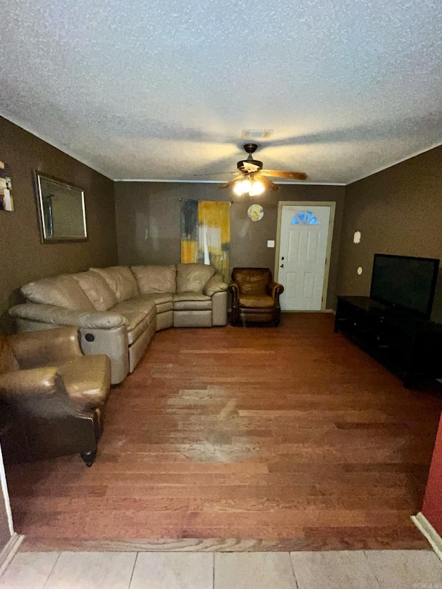 living room with ceiling fan and a textured ceiling