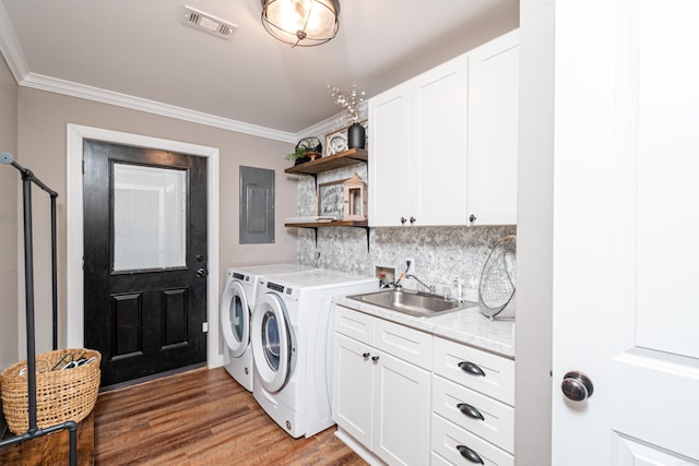 laundry room with cabinets, ornamental molding, sink, and washing machine and dryer