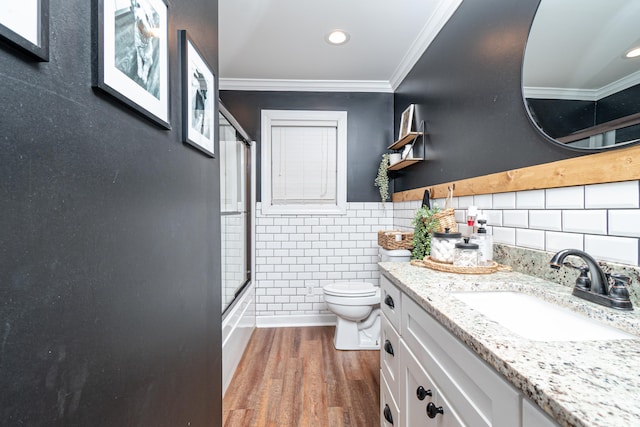 full bathroom featuring tile walls, wood-type flooring, ornamental molding, and enclosed tub / shower combo