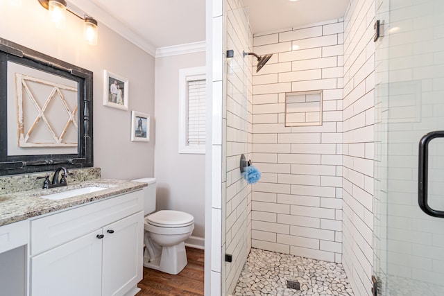 bathroom with toilet, ornamental molding, vanity, a shower with door, and hardwood / wood-style floors