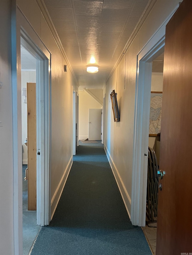 corridor with crown molding and carpet