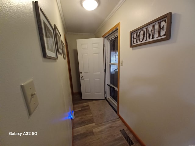 doorway to outside with crown molding and dark wood-type flooring