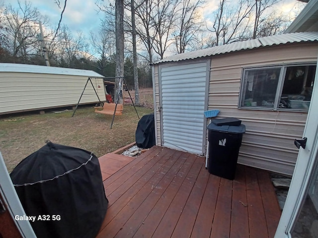 wooden deck with a grill and a storage shed