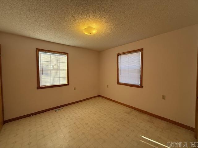 unfurnished room featuring a textured ceiling