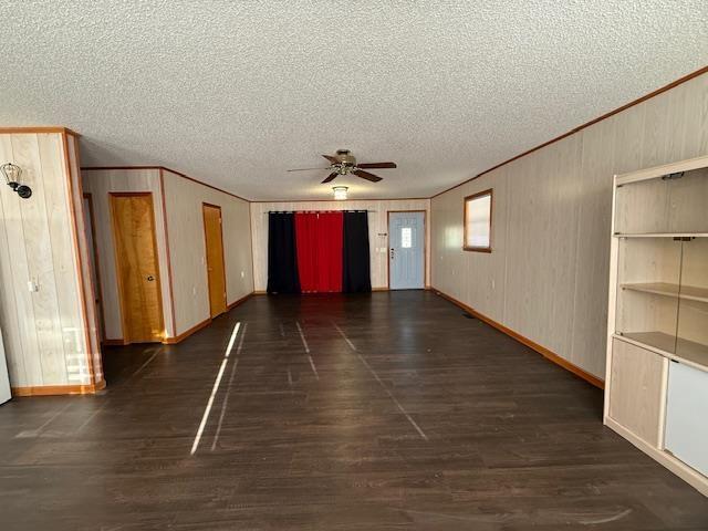 empty room featuring a textured ceiling, ornamental molding, dark hardwood / wood-style floors, and ceiling fan