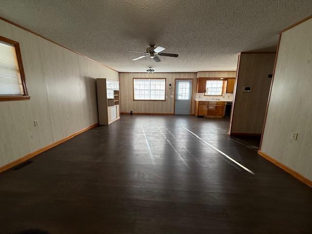 unfurnished living room featuring ceiling fan and a textured ceiling